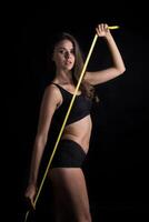 Beautiful young woman measuring her figure size with tape measure. photo