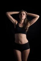 Beautiful woman with healthy body on black background photo