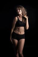 Beautiful woman with healthy body on black background photo