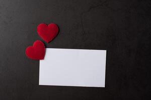 Red Heart paper and blank with note card on wall background. photo