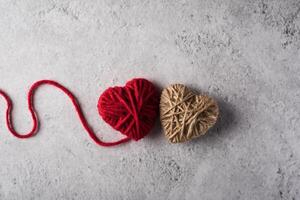 Red yarn heart shaped on the wall background. photo