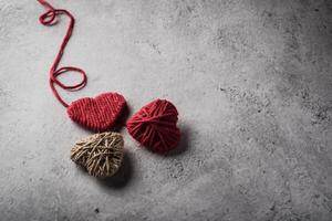 Red yarn heart shaped on the wall background. photo