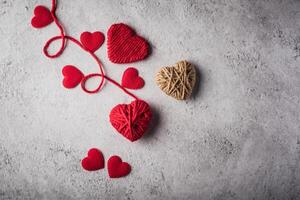 Red yarn heart shaped on the wall background. photo