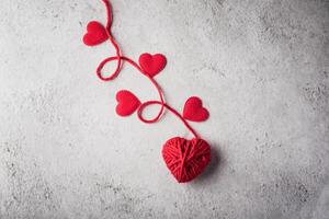 Red yarn heart shaped on the wall background. photo