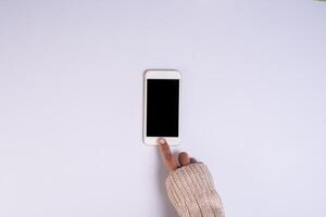 Top view hand holding cell phone on white background. photo