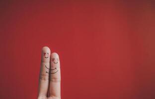 Finger with emotion on red background. photo