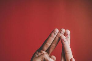 Finger with emotion on red background. photo