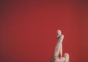 Finger with emotion on red background. photo