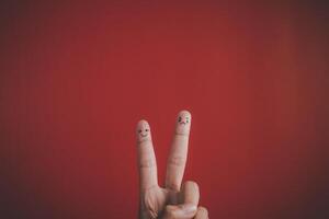 Finger with emotion on red background. photo