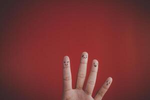 Finger with emotion on red background. photo