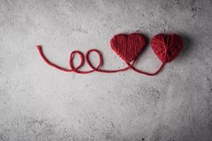Red yarn heart shaped on the wall background. photo