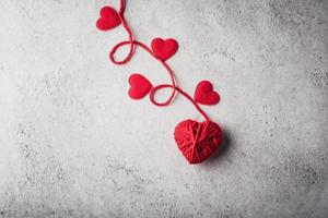 Red yarn heart shaped on the wall background. photo