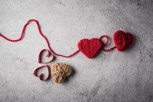 Red yarn heart shaped on the wall background. photo