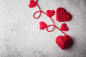 Red yarn heart shaped on the wall background. photo