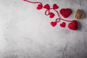 Red yarn heart shaped on the wall background. photo