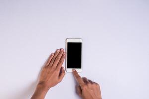 Top view hand holding cell phone on white background. photo