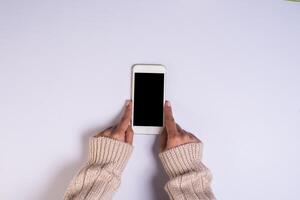 Top view hand holding cell phone on white background. photo