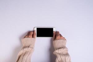 Top view hand holding cell phone on white background. photo