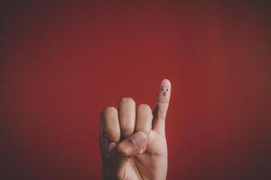 Finger with emotion on red background. photo