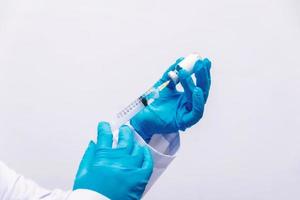 Doctor in laboratory holding a syringe with liquid vaccines photo