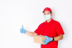 A delivery man wearing a red shirt and hat holds a parcel box photo