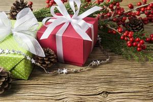 Christmas decoration of red gift box and winterberry on old wood