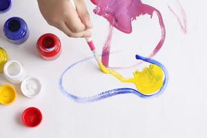 Asian boy use paintbrush and watercolor painting in paper photo