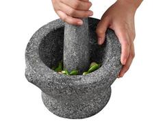 Woman use stone Mortar and Pestle for cooking green curry paste photo