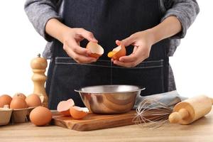 Woman hands to separate egg white and yolks with egg shells photo