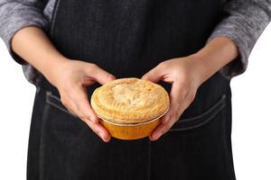 Mujer mantenga pastel de carne sobre fondo blanco. foto