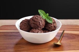 Helado de chocolate en un tazón blanco sobre la tabla de cortar foto