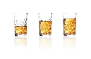 Whisky en vaso de chupito sobre fondo blanco. foto