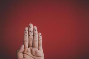 Finger with emotion on red background. photo