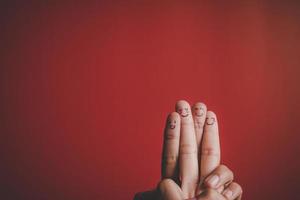 Finger with emotion on red background.