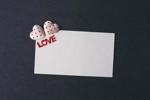 corazón y en blanco con tarjeta de nota sobre fondo rojo. foto