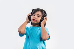 Little girl listening to music on wireless headphones. photo