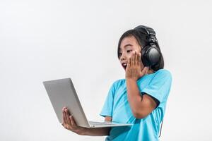 Little girl using laptop computer and listening lesson online. photo