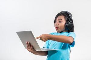 Little girl using laptop computer and listening lesson online. photo