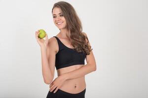 mujer de belleza sosteniendo manzana verde mientras aislados en blanco. foto