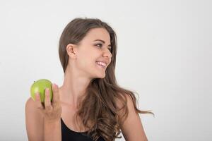 mujer de belleza sosteniendo manzana verde mientras aislados en blanco. foto