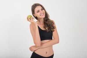 mujer de belleza sosteniendo manzana verde mientras aislados en blanco. foto