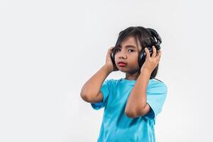 Little girl listening to music on wireless headphones. photo