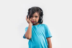 Little girl listening to music on wireless headphones. photo