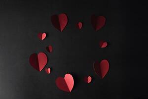 Red Hearts paper on black background photo