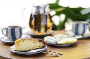 Organic mango cake and herbal tea set on rustic cafe table outdoors photo