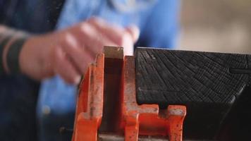 un carpintero cepilla una pequeña tabla de madera video