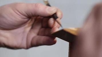 el artesano marca un trozo de madera