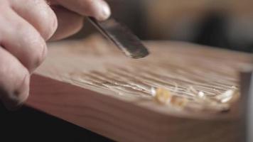 artesão trabalha uma placa de madeira de pinho com um cinzel video