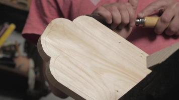 carpintero corta el exceso en una tabla de madera con un cincel plano video