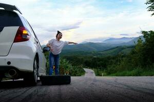 Woman hitchhiking on the road on the public road in the forest area photo